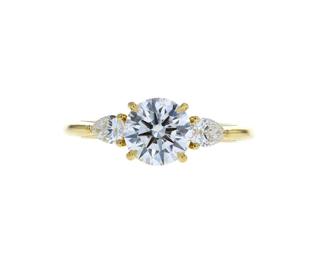 three stone round diamond engagement ring with pear side stones yellow gold